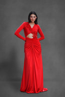 Model wearing The Ember Gown in cherry red with embellished bodice and front cut-out on a gray background.